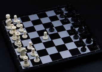 Chess game opening on chessboard. Checked board with figure on black background. Chess figurine...