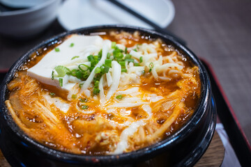 Close up of ‘Kimchi Jjigae’ or Kimchi soup in a black clay pot. It's a Korean traditional food.