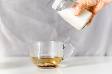 Pouring milk on a cup of tea 