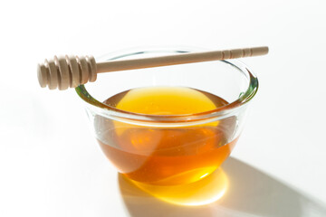 Fresh honey bee in bowl with dipper on white background.