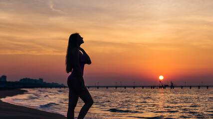 Fototapeta premium silhouette girl with long hair and fit body posing on the beach