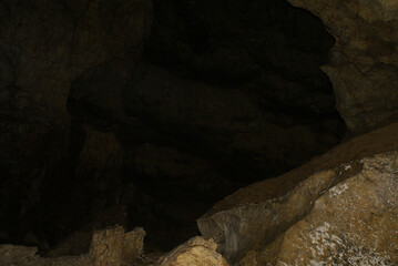Obraz premium A cave with stalactites and stalagmites in an underground cave, rocks.