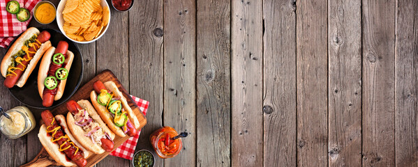 BBQ hot dog corner border. Top view table scene with a dark wood banner background. Copy space.