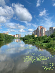 Fototapeta na wymiar Russia, Moscow region, the city of Balashikha. Pekhorka river in summer sunny day and view of Zarechnaya street