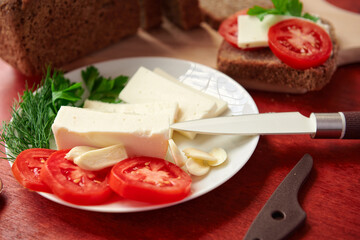 healthy food - fresh bread and feta cheese on a wooden background, tomatoes, greens and vegetables