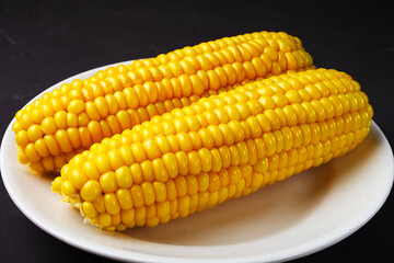 boiled corn on a white plate, close-up