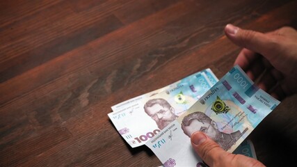 Ukrainian business man holds paper hryvnia taking credit from the bank. Inflation concept. Investment concept. Close up shot. Text space at left side.