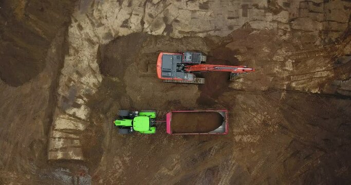 Baustelle: Tiefbau Erdbau Bauarbeiten: Bagger verl&auml;dt Erde, Sand auf einen Muldenkipper, Vogelperspektive