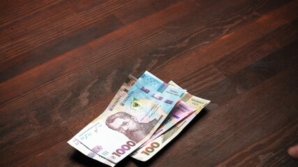 Pack of new Ukrainian Paper hryvnia money different face value at wooden table background. Cash...