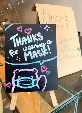 Sign At A Restaurant, Small Local Business, During COVID-19 Pandemic Recovery, Thanking Customers For Wearing A Mask And A Brown Take-out Bag