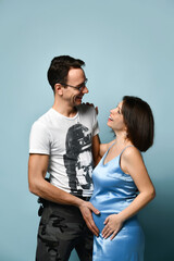 young couple waiting for the baby. A pregnant girl with her boyfriend hugs and looks at each other.