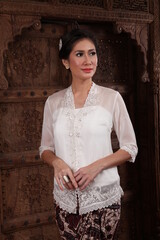 Beautiful woman wearing an elegant kebaya, kebaya is a traditional dress worn by Indonesian and Malaysian women made from gauze cloth worn with batik.

