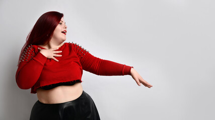 Obese ginger lady in red spiked top, black bra, leather skirt. Acting like letting someone kiss her...