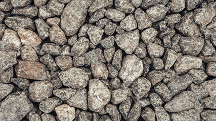 Close up shot of sea pebbles. Rock or stone texture. Background of pebbles. Wet stones on the coast. Multicolored pebbles on the seashore. Sea shore, coastline, waterside.