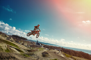 Extreme concept, challenge yourself. Extreme jump on a motorcycle on a background of blue sky with...