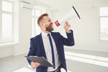 Male real estate agent shioting in megaphone smiling in white real estate room apartment home