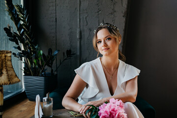 Young beautiful lady in the cafe with the bouquet of flowers.
