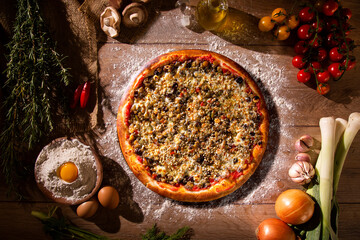 Traditional zucchini Pizza with black olive and cheese. Top view on wood background, close up. Traditional Brazilian Pizza