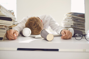 Tired busy businessman sleeping at a table with a computer.