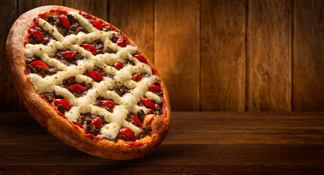 Brazilian pizza with meat, tomato and cream cheese. Side view on red background, close up. Traditional Brazilian Pizza