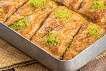 Traditional Turkish dessert in tray on wooden table