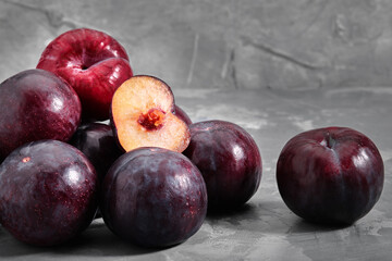 Ripe blue plums lie on a concrete stone background. Natural fruit background with place for text. Copy space. Autumn harvest background.
