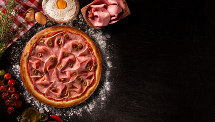 Brazilian pizza with mortadella and green olive. Top view on black concrete background, close up. Traditional Brazilian Pizza