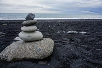 stone pyramid on the black coast of the Atlantic ocean, nature of Iceland
