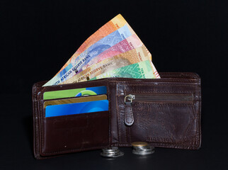 Wallet partially showing South African bank notes and some coins