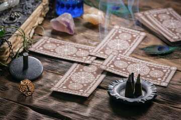 Tarot cards and zodiac wheel on the wooden table background.