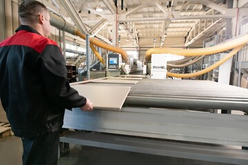 Anonymous man working with chipboard on factory