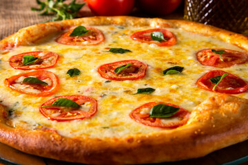 Pizza Margherita on wood background. Pizza Margarita with Tomatoes, Basil and Mozzarella Cheese close up. Traditional Brazilian Pizza.