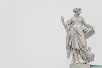 Old roof statue of a Renaissance Era woman philosopher and poet with book and chicken in Potsdam at white creamy background and copy space for text, Germany - obrazy, fototapety, plakaty