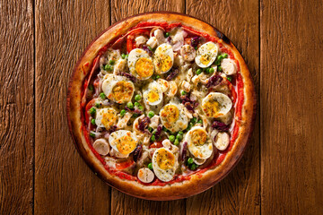 Traditional Portuguese Pizza with egg, olive, palm heart and pea. Top view on wood background, close up. Traditional Brazilian Pizza