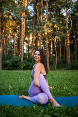 Beautiful brunette Girl sitting in a yoga pose in nature.Pashasana