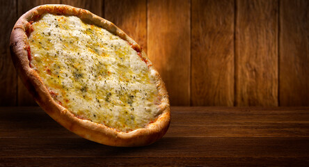 Pizza four cheese,. side view on wood background, close up. Traditional Brazilian Pizza.