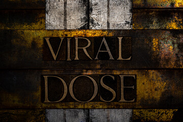 Viral Dose text formed with real authentic typeset letters on vintage textured silver grunge copper and gold background
