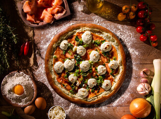Brazilian pizza with salmon, leek and cream cheese. top view on wood background, close up....