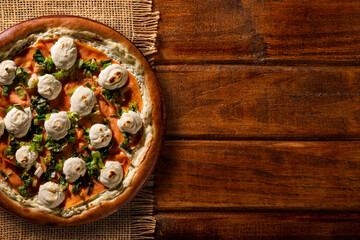 Brazilian pizza with salmon, leek and cream cheese. top view on wood background, close up. Traditional Brazilian Pizza