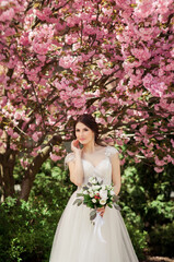 Obraz na płótnie Canvas beautiful bride in sakura blossom
