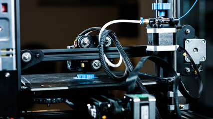 3D plastic printer during work in a factory three dimensional printing. Close-up detail.