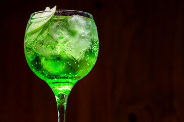 Gin and green apple cocktail on wood background
