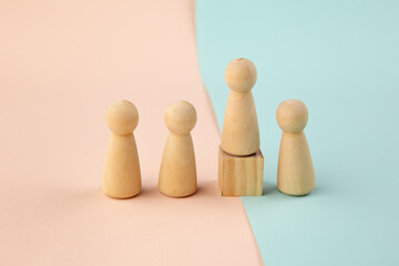 Wooden figure standing on the box for show influence and empowerment on colorful background. Concept of business leadership for leader team.