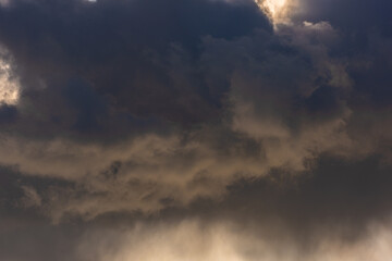 Very dark clouds lit up from behind and under by diffused sunlight.