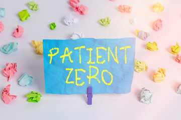 Conceptual hand writing showing Patient Zero. Concept meaning primary disease carrier of the highlycontagious disease Colored crumpled paper empty reminder white floor clothespin