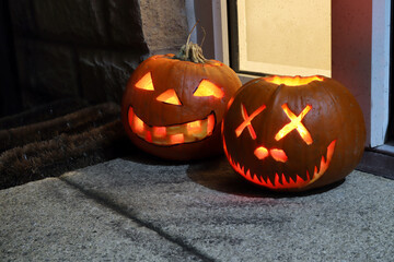 Pair of Halloween jack o lantern pumkins on a doorstep