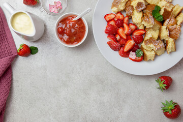 Kaiserschmarren or Kaiserschmarrn, traditional Austrian or German sweet pancake dessert, with berry, strawberry jam or rote grutze and vanilla pudding sauce. Top view. Copy space.