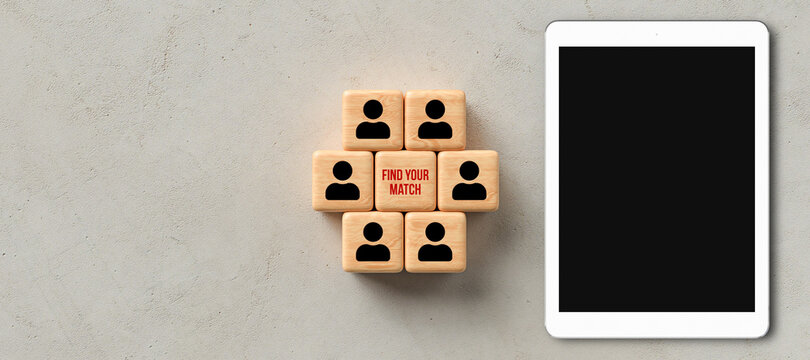cubes with people icons and the message FIND YOUR MATCH besides a tablet on concrete background