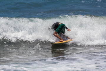 Surfer on a board in the waves of the sea falls into the waves.