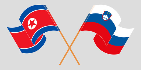 Crossed and waving flags of North Korea and Slovenia